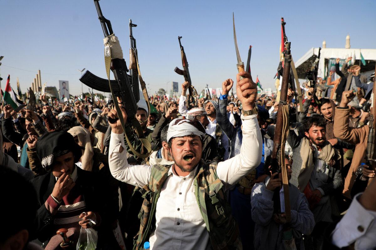 Houthi fighters brandish their weapons during a protest following U.S. and British forces’ strikes amid the ongoing battles between Israel and the Hamas terrorist group in Gaza, in the Houthi-controlled Sanaa, Yemen, on Jan. 12, 2024. (Mohammed Huwais/AFP via Getty Images)