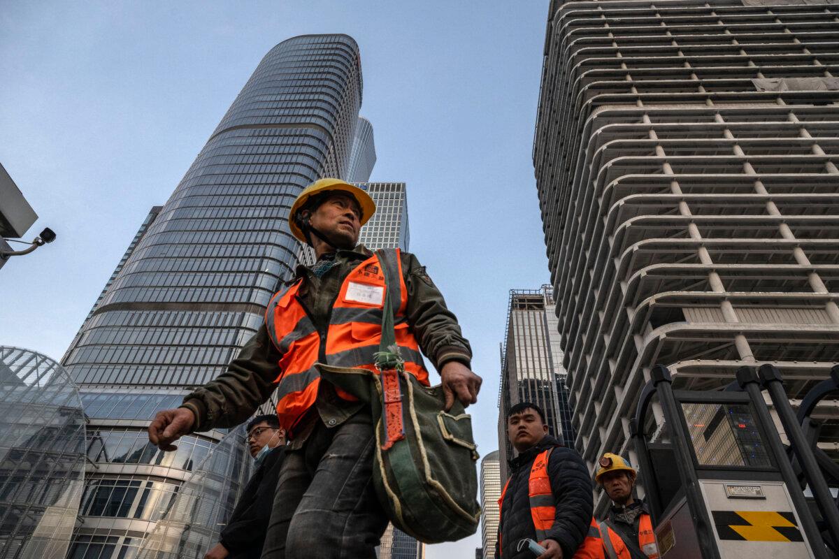 Construction workers leave a building site for a new office tower in the Central Business District in Beijing on April 3, 2025. (Kevin Frayer/Getty Images)