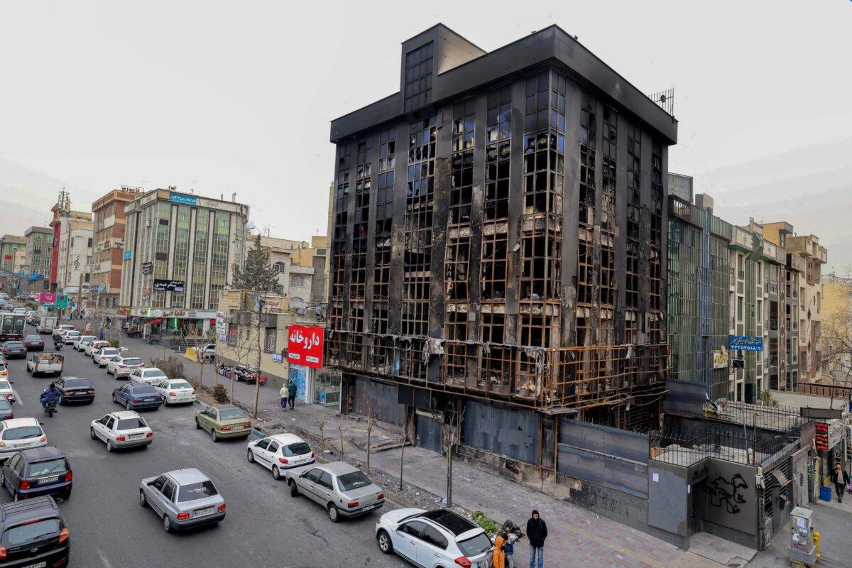 People walk past a building destroyed during public protests in Tehran, Iran, on Jan. 19, 2026. (Atta Kenare/AFP via Getty Images)