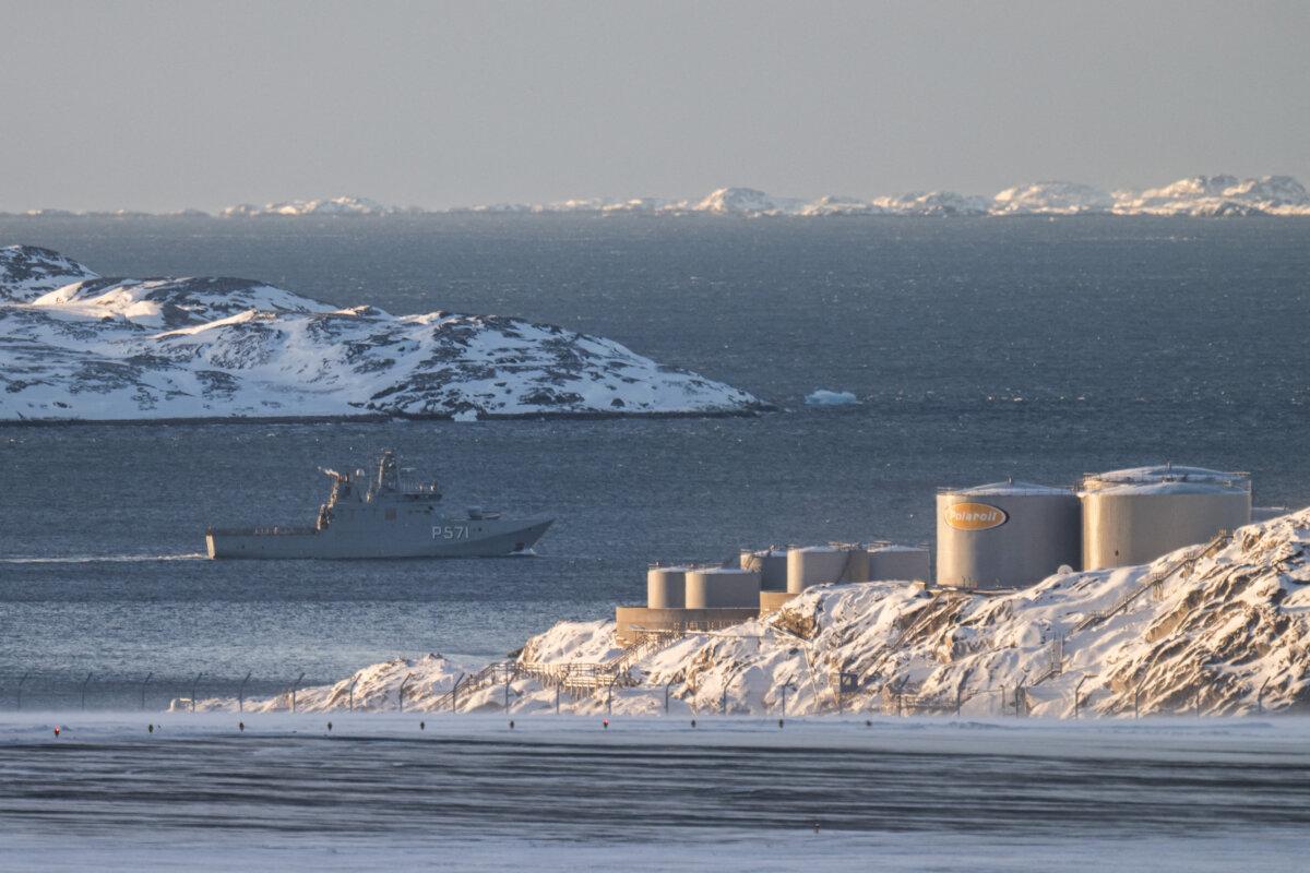 A patrol vessel marked "P571" sails past fuel storage tanks along the coastline near Nuuk Airport, with snow-covered islands in the background, in Nuuk, Greenland, on January 20, 2026. (Jonathan Nackstrand/ AFP via Getty Images)