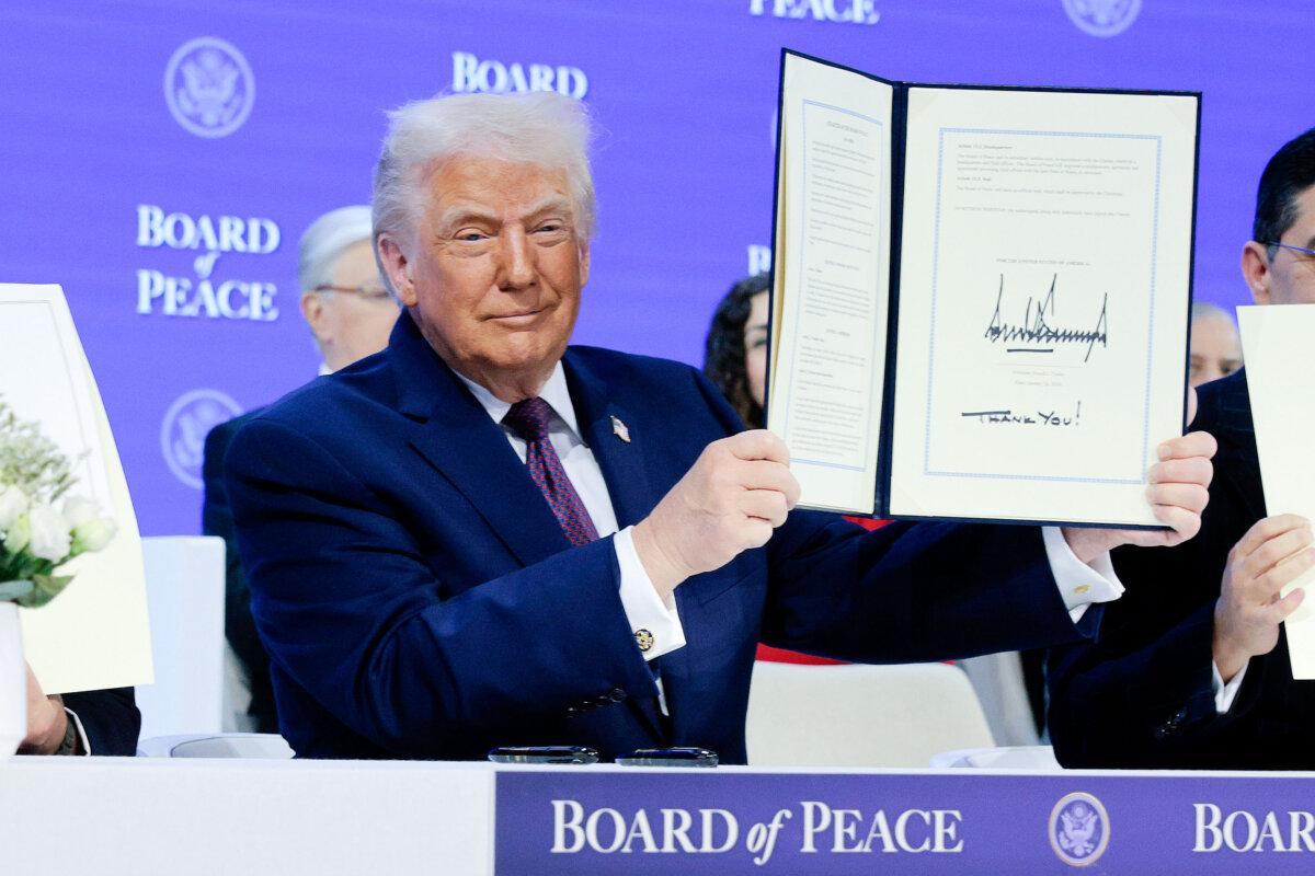U.S. President Donald Trump holds up his signature on the founding charter of the Board of Peace at the World Economic Forum in Davos, Switzerland, on Jan. 22, 2026. (Chip Somodevilla/Getty Images)