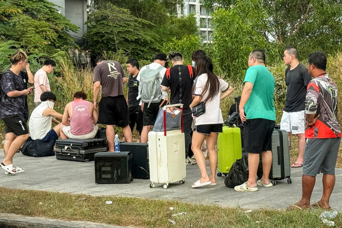 Workers gather with their luggage after leaving a suspected scam center compound in Sihanoukville, Cambodia, on Jan. 15, 2026. (Tang Chhin Sothy/AFP via Getty Images)