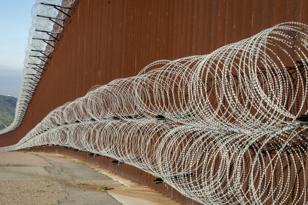Razor wire installed by United States Military personnel is seen on the United States border wall outside of San Diego, on Jan. 20, 2026. (John Fredricks/The Epoch Times)