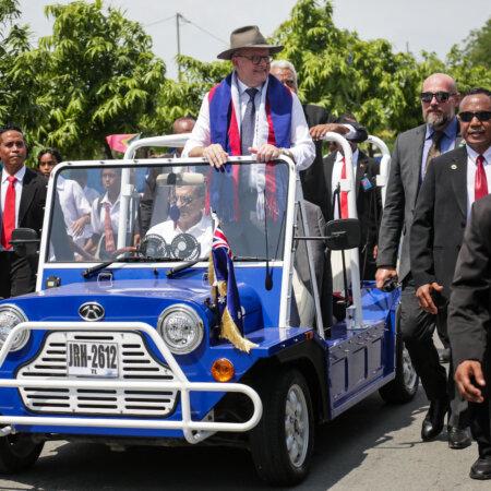 Australia's Prime Minister Anthony Albanese (C) reacts from an open-top car owned and driven by East Timor's President Jose Ramos-Horta (seated) upon his arrival in Dili, East Timor on Jan. 28, 2026. (Valentino Dariell de Sousa / AFP via Getty Images)