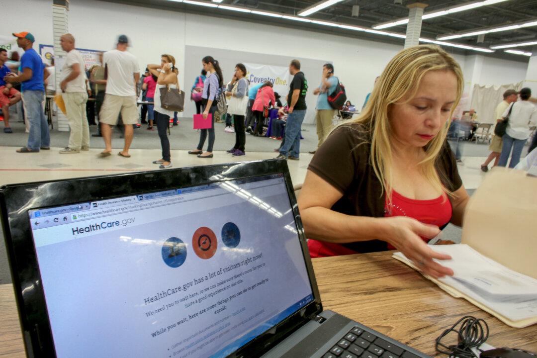 A customer meets with an insurance agent while waiting for the Affordable Care Act website to come back online to purchase a health insurance plan in Miami on March 31, 2014. (Joe Raedle/Getty Images)