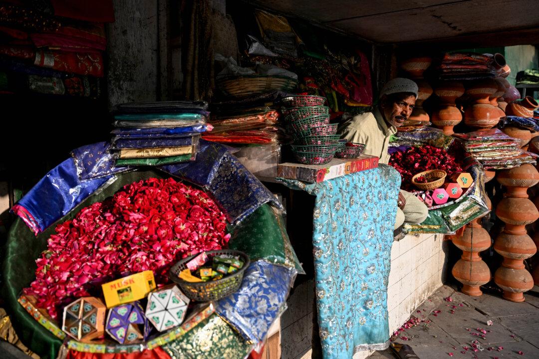 A vendor selling religious offerings waits for customers at his shop outside a shrine in New Delhi on February 3, 2026. (Photo by Sajjad HUSSAIN / AFP via Getty Images)