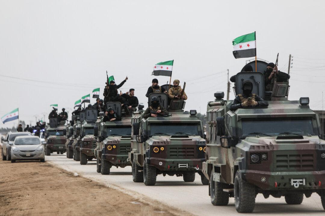 Syrian government forces drive along a road as they enter the Kurdish-majority city of Qamishli on February 3, 2026. Syrian government forces started entering Qamishli on February 3, under an integration deal agreed with the Kurds last week, state media reported. The move comes after security personnel entered the mixed Kurdish-Arab city of Hasakeh and the countryside around the Kurdish town of Kobane a day earlier, as part of the comprehensive agreement to gradually integrate Kurdish forces and institutions into the state. (Photo by Bakr ALkasem / AFP via Getty Images)