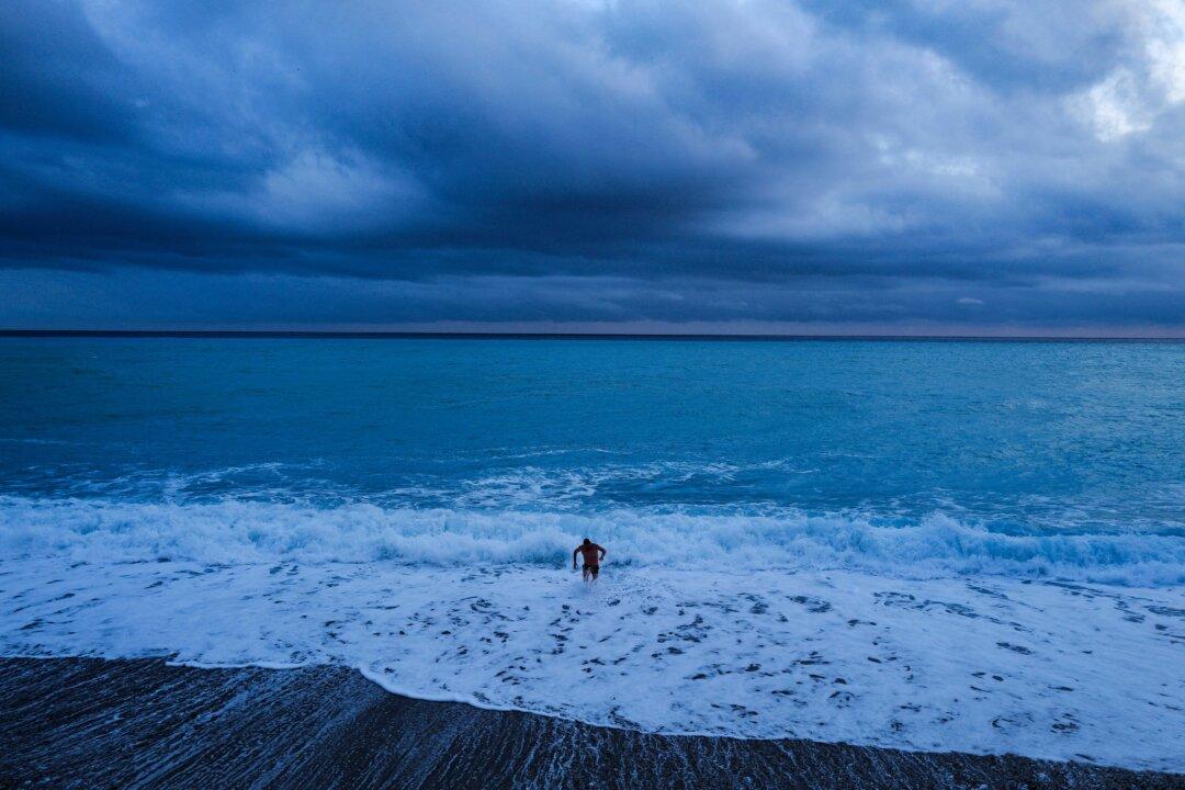 A man comes out after a bath on the Mediterranean sea on the French riviera city of Nice, on February 3, 2026. (Photo by Valery HACHE / AFP via Getty Images)