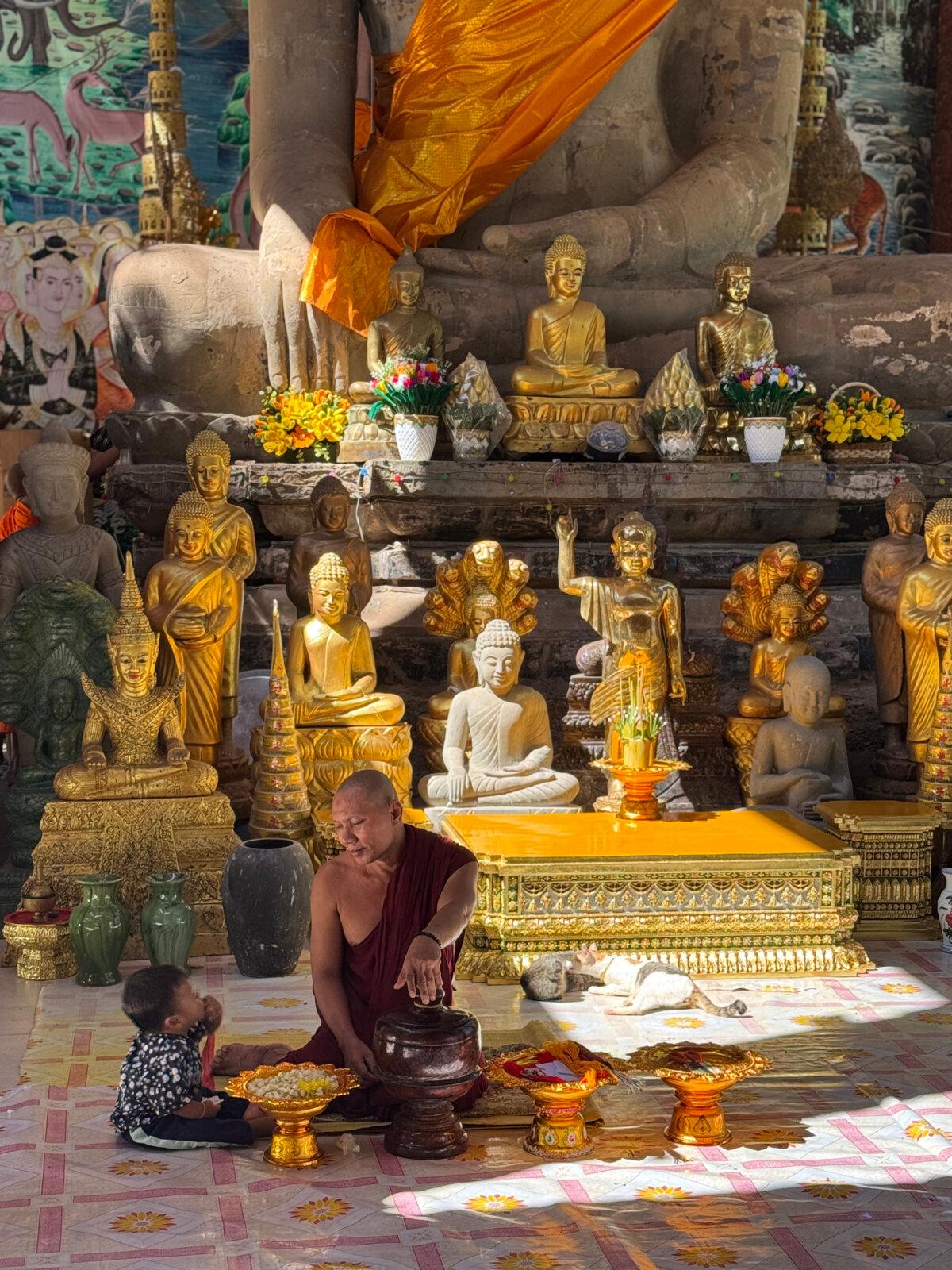 A Buddhist monk talks to a child not too far from the famed temple complex of Angkor Wat in Cambodia, where we spent the final two days of the trip. (Lori Rackl/TNS)