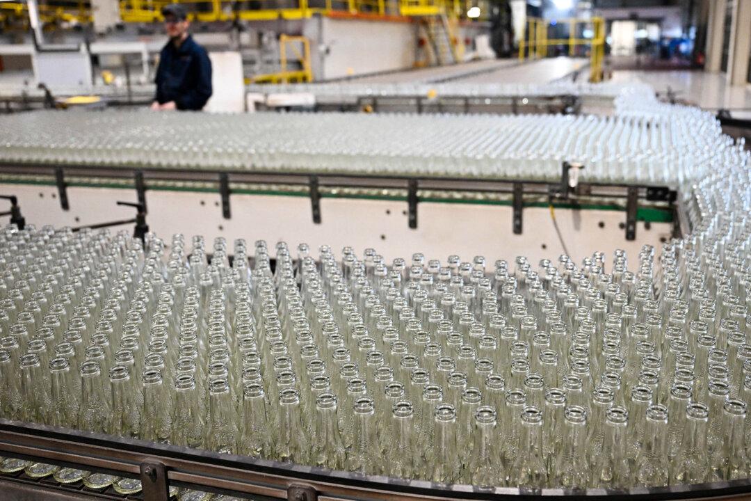 An employee monitors newly manufactured bottles at a factory run by British glass containers maker and filler, Encirc, in Elton, north-west England on February 4, 2026. (Photo by Paul ELLIS / AFP via Getty Images)