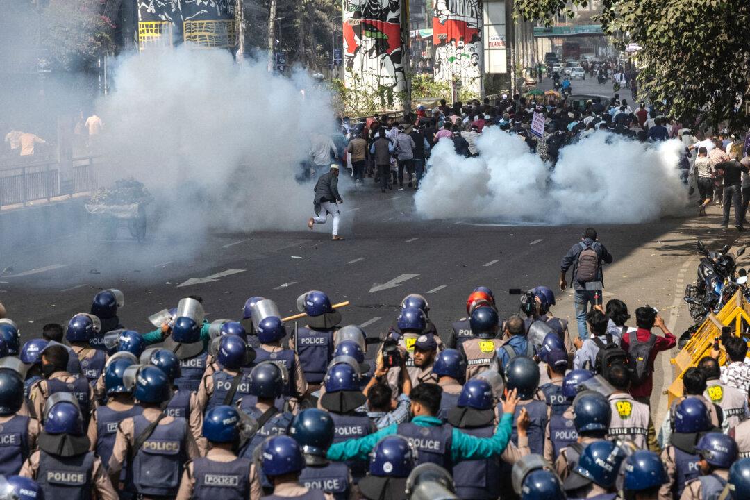 Police personnel fire tear gas shells to disperse government employees demanding implementation of the new pay scale during a protest in Dhaka on February 6, 2026. (Photo by Abdul GONI / AFP via Getty Images)