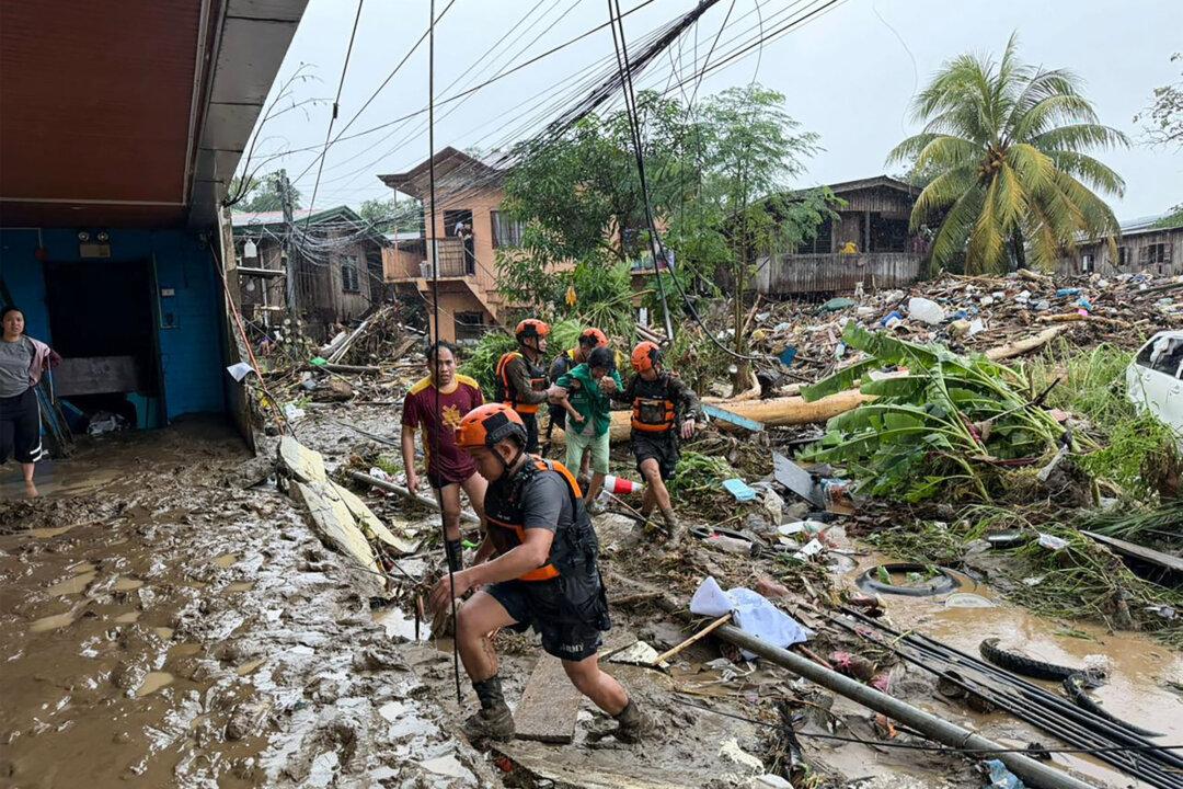 TOPSHOT - Rescuers evacuate a woman after Tropical Storm Penha hit the area in Iligan, Lanao del Norte province on February 6, 2026. (Photo by Merlyn Manos / AFP via Getty Images)