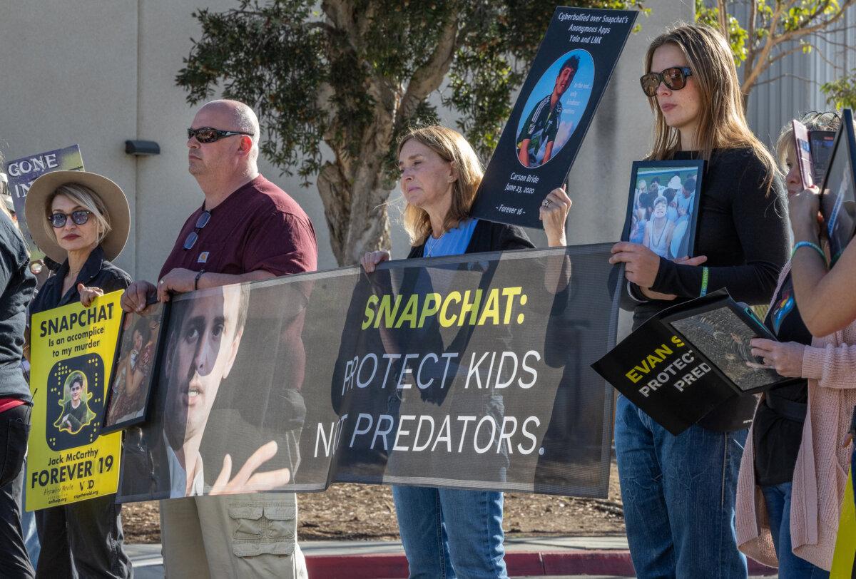 Parents who blame social media platform Snapchat for contributing to their loved one's death, stand near a photo of Snap Inc. CEO Even Spiegel, near the offices of Snap Inc., in Santa Monica, Calif., on Feb. 12, 2026. (John Fredricks/The Epoch Times)