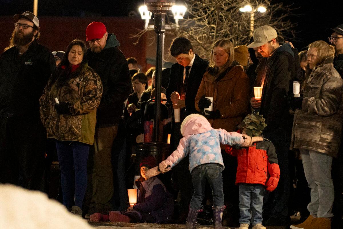 Community members mourn during a candlelight vigil for the victims of Tumbler Ridge Secondary School where a mass shooting took place a day earlier, in the small town of Tumbler Ridge, B.C., on Feb. 11, 2026. (Paige Taylor White / AFP via Getty Images)