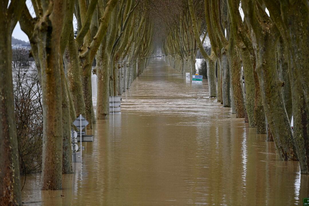 TOPSHOT - This photograph shows the overflowing Garonne river inundating a road in Tonneins, south-western France on February 13, 2026, after winds of Storm Nils swept across France. Storm Nils, which swept across France for two days, has claimed a second life according to the government in the south-west, where a red alert remains in place for flooding on the Garonne river. France's government spokesperson announced on the morning of February 13, 2026, on French TV channel TF1 the death of a man who was "on a ladder in his garden" in Tarn-et-Garonne. (Photo by Christophe ARCHAMBAULT / AFP via Getty Images)