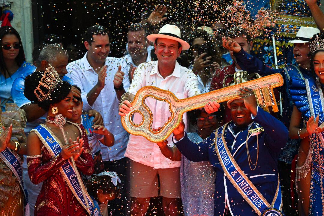 TOPSHOT - King Momo Cedric da Costa (R) receives the key of the city from Rio de Janeiro Mayor Eduardo Paes (C) during the official Carnival opening ceremony in Rio de Janeiro, Brazil, on February 13, 2026. (Photo by Mauro PIMENTEL / AFP via Getty Images)