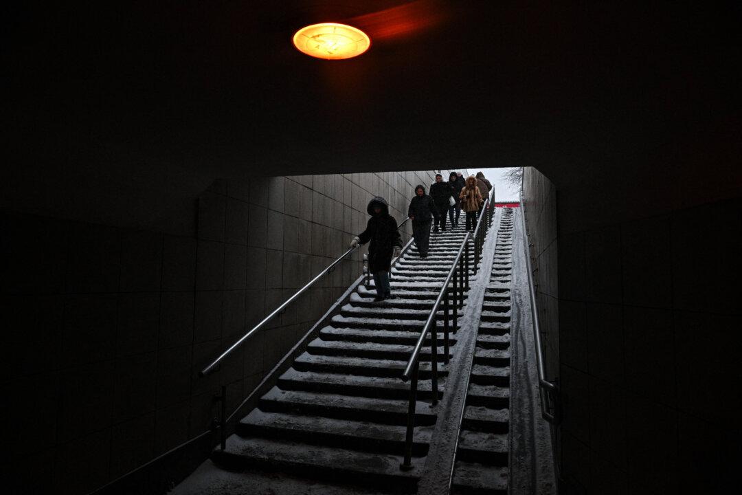 People walk down the stairs at a metro station in Moscow on February 16, 2026. (Photo by Hector RETAMAL / AFP via Getty Images)