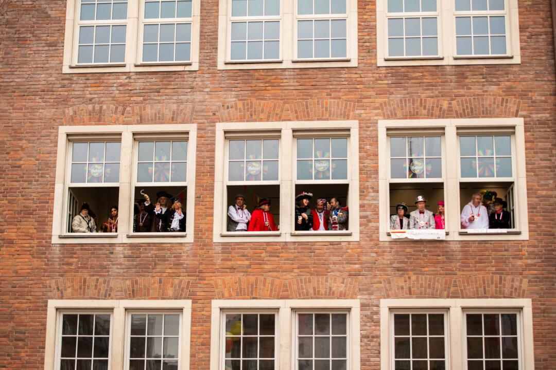 DUESSELDORF, GERMANY - FEBRUARY 16: Carnival goers watch the annual Rose Monday parade on February 16, 2026 in Dussledorf, Germany. Rose Monday is the highlight of Carnival season, especially in western Germany, where parade float designers are famous for often searing and irreverent depictions of German and foreign politicians. (Photo by Hesham Elsherif/Getty Images)