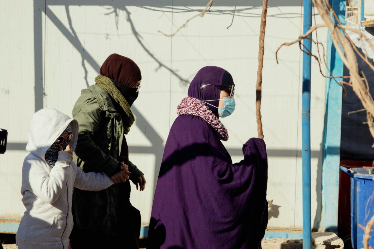 Australian families affiliated with ISIS walk along a path before departure inside the Roj camp in al Malikiyah, Syria, on Feb. 15, 2026. (Amjad Kurdo/Middle East Images/AFP via Getty Images)