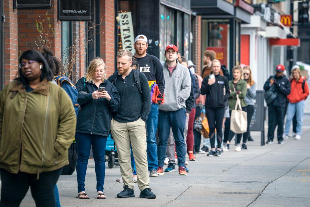 People wait in a line to get into a Trader Joe’s grocery store in Washington on April 1, 2020. Psychologist Debra Kissen said that amid “the social isolation loneliness epidemic,” people are realizing they’re in pain and are starting to interact and talk more with others. (Drew Angerer/Getty Images)