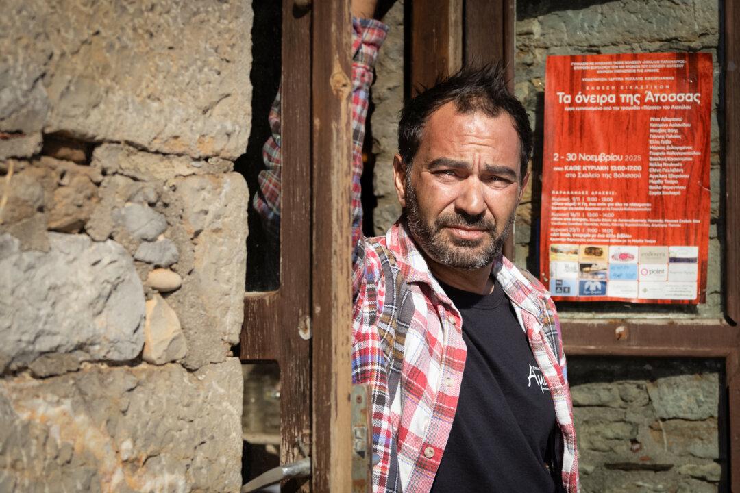 Sotiris Theodorou stands in a doorway in Limanáki, Greece, on Nov. 14, 2025. Theodorou and a handful of residents in isolated, depopulated villages succeeded in forcing the government to halt a proposed large-scale antimony mine. (John Fredricks/The Epoch Times)