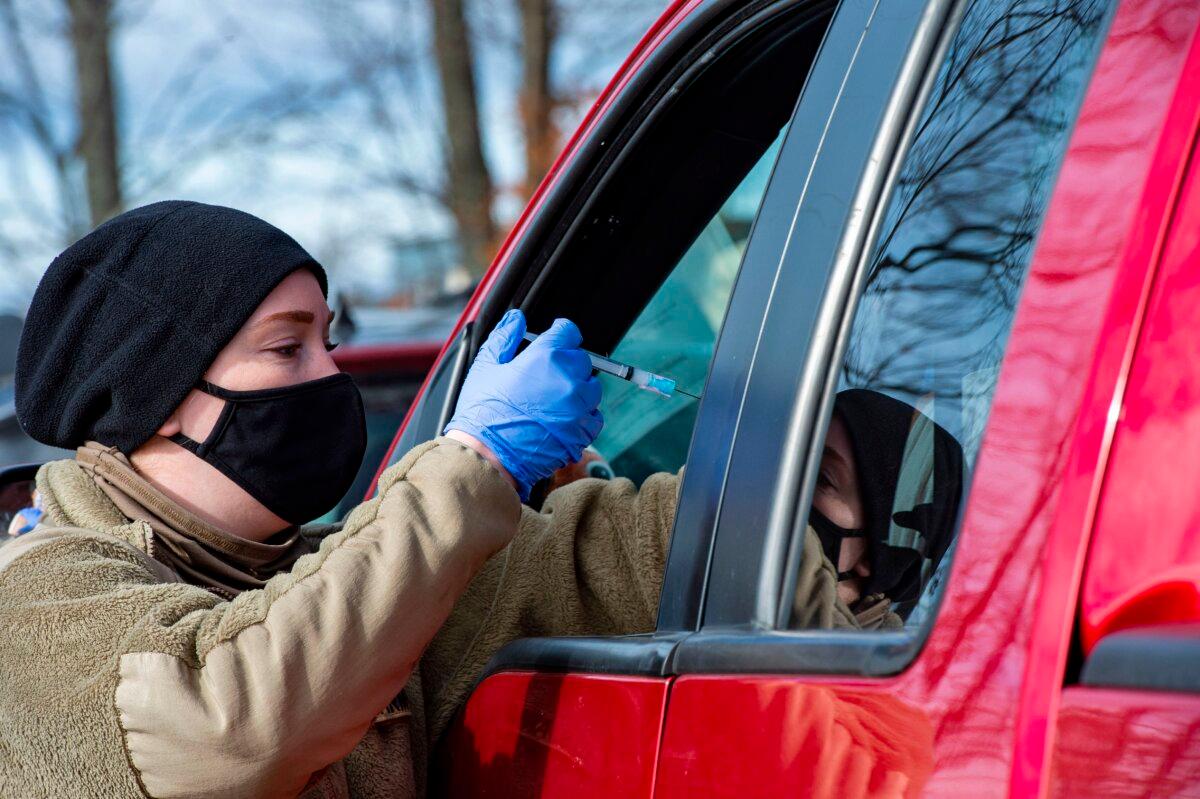 A military specialist vaccinates a man in Londonderry, N.H., on Feb. 4, 2021. (Joseph Prezioso/AFP via Getty Images)