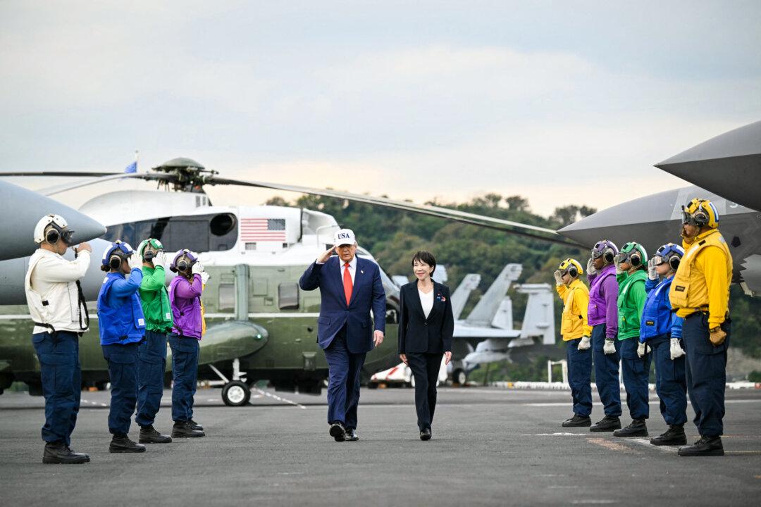 U.S. President Donald Trump and Japan’s Prime Minister Sanae Takaichi arrive aboard U.S. Navy aircraft carrier USS George Washington at the U.S. naval base in Yokosuka, Japan, on Oct. 28, 2025. (Andrew Caballero-Reynolds/AFP via Getty Images)