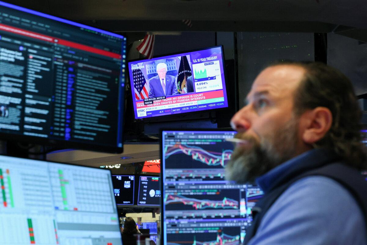 A press conference by President Donald Trump on tariffs is displayed on a television as traders work on the floor of the New York Stock Exchange on Feb. 20, 2026. (Michael M. Santiago/Getty Images)