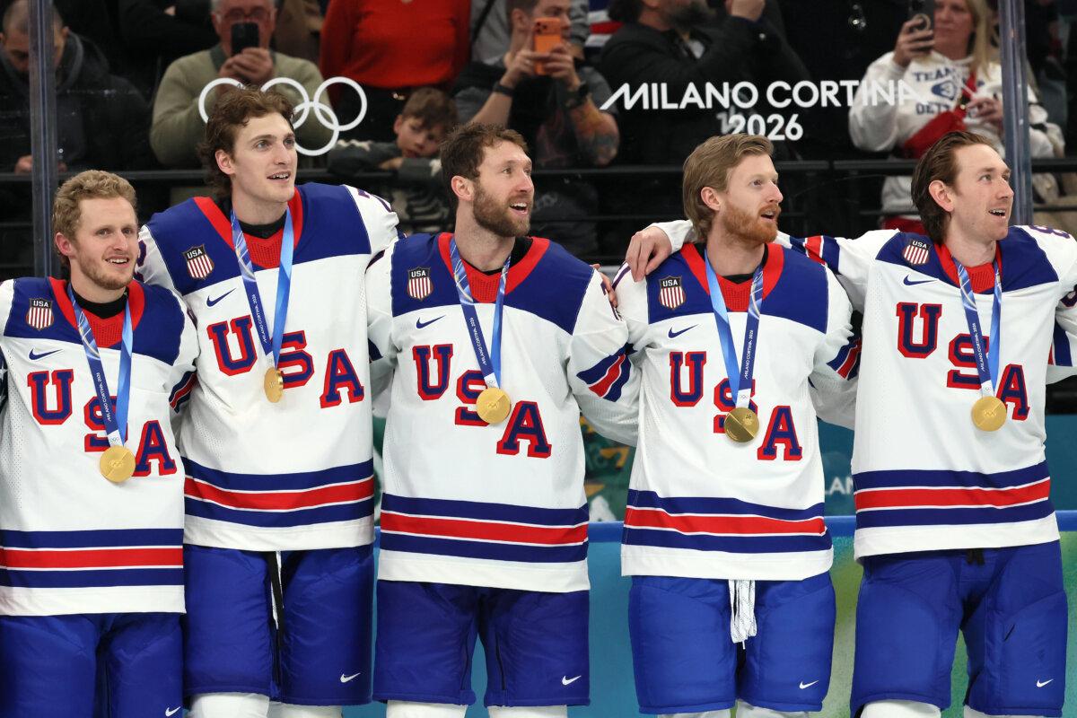 Jake Guentzel #59, Tage Thompson #72, Jaccob Slavin #74, Kyle Connor #81 and Jake Sanderson #85 of Team United States listen to the national anthem during the medal ceremony for Men's Ice Hockey following their gold-medal win over Canada at the 2026 Winter Olympic games at Milano Santagiulia Ice Hockey Arena in Milan, Italy, on Feb. 22, 2026. (Bruce Bennett/Getty Images)