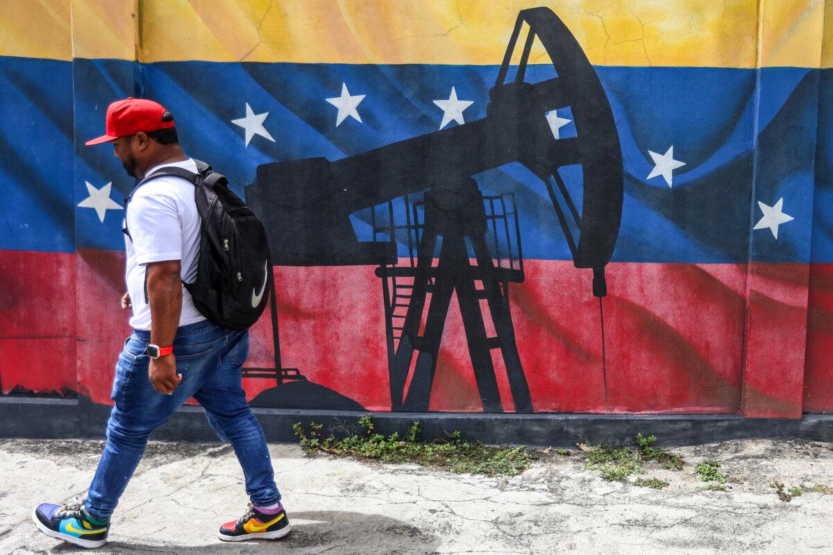 A man passes a mural depicting an oil pumpjack on a Venezuelan flag in Caracas on Jan. 15, 2026. (Pedro Mattey/AFP via Getty Images)