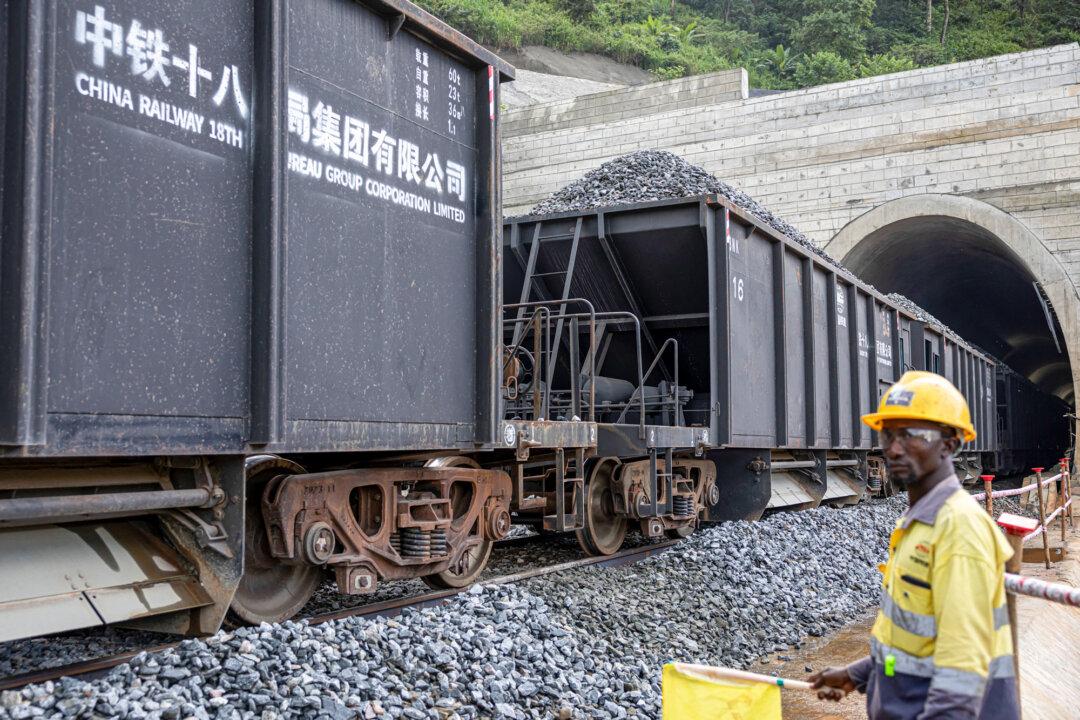 A China Railway employee watches as a train transports rocks at the SimFer mining complex in the Simandou mountain range in Guinea on Sept. 2, 2025. Washington has recently reached bilateral framework agreements on critical minerals with 21 countries, including Australia, the Democratic Republic of the Congo, Guinea, and Japan, according to the State Department. (Patrick Meinhardt/AFP via Getty Images)