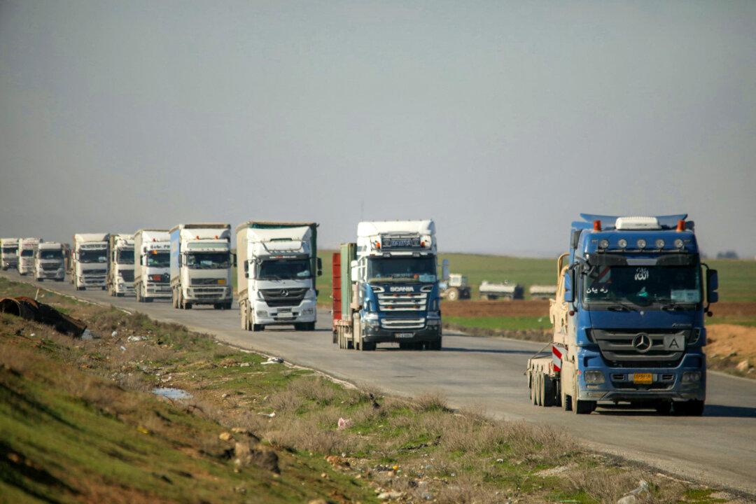 Trucks in a US military convoy transporting military equipment move along a highway outside Qamishli in Syria's northeastern Hasakah province on February 23, 2026. The US on February 23 began withdrawing from Qasrak military base in Syria, still under the control of Kurdish forces, a Kurdish official who requested anonymity told AFP. (Photo by Delil SOULEIMAN / AFP via Getty Images)