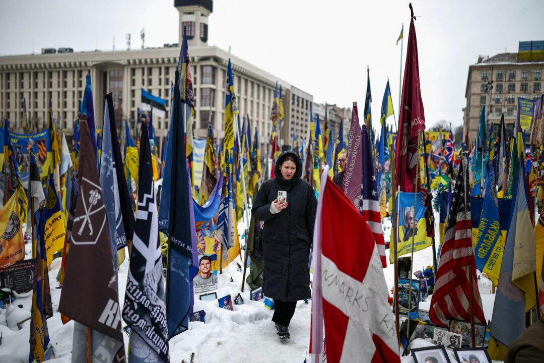 TOPSHOT - A person walks through a makeshift memorial to fallen Ukrainian and foreign soldiers in Independence Square in Kyiv on February 23, 2026, as the conflict with Russia reaches its four-year mark. Russia launched its full-scale invasion of Ukraine on February 24, 2022, unleashing the deadliest war in Europe since World War II. (Photo by HENRY NICHOLLS / AFP via Getty Images)
