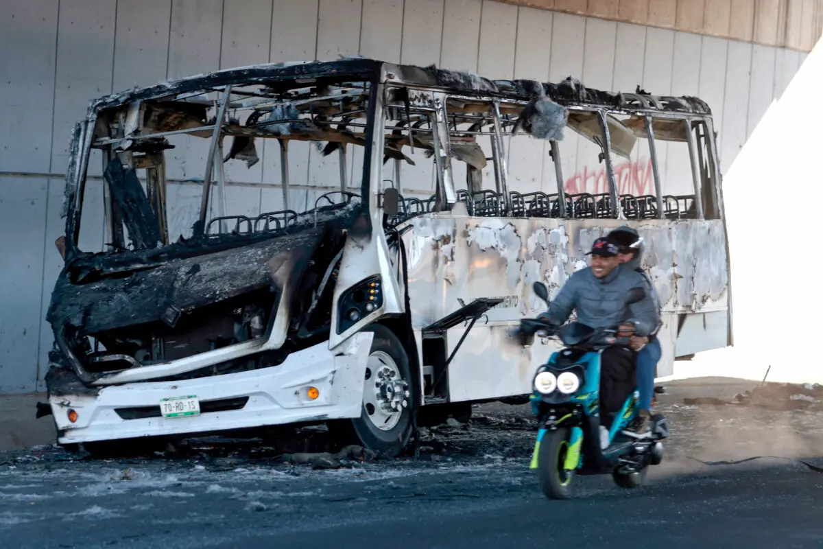 Uneasy Calm Returning to Mexico After Chaos Over Killing of Drug Lord ‘El Mencho’ | USNN World News A motorcycle rides past a burned bus used to block an avenue in Tonala, Jalisco, Mexico, on Feb. 23, 2026. (Ulises Ruiz/AFP via Getty Images)