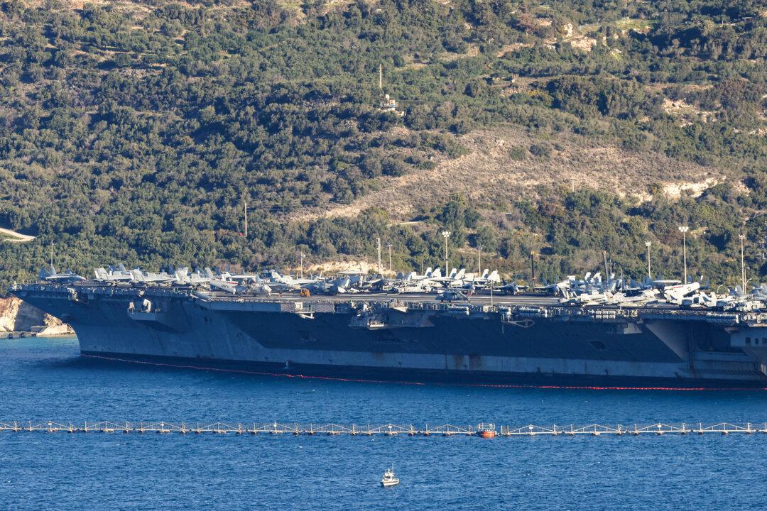 US aircraft carrier USS Gerald Ford is pictured docked at Souda Bay in the Greek Mediterranean island of Crete, on February 24, 2026. Upon military orders by US President Donald Trump, the world's largest vessel is on its way to the Middle East to join 13 more warships stationed in the region: the aircraft carrier USS Abraham Lincoln, which arrived late last month, nine destroyers and three frigates. (Photo by Costas METAXAKIS / AFP via Getty Images)