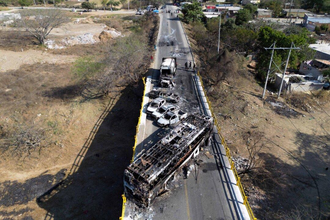 Aerial view of burned vehicles over the "La Desembocada" bridge in Puerto Vallarta, Jalisco State, Mexico, on February 24, 2026. Puerto Vallarta is known as a paradise. But following the narco chaos on February 22 following the death of the druglord "El Mencho," the tourist destination seems more like a war-zone, where dozens of incinerated vehicles line the streets and vandalized stores remain empty. (Photo by Alfredo ESTRELLA / AFP via Getty Images)