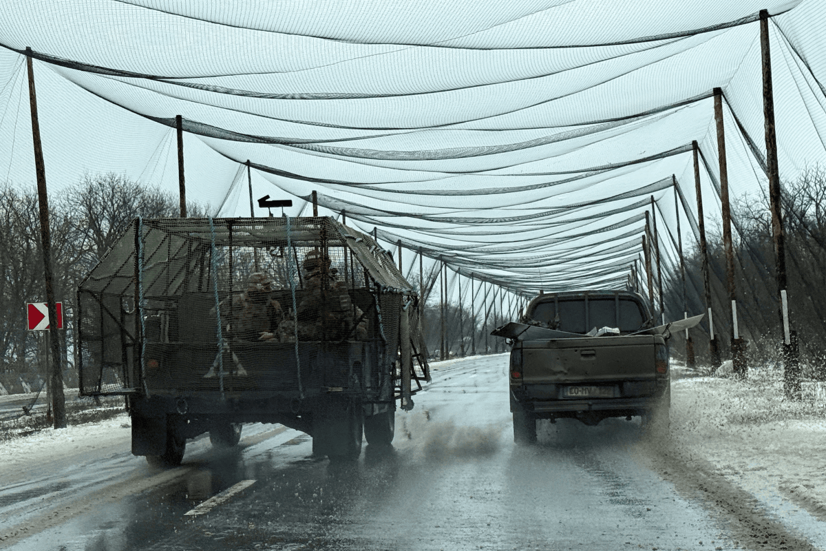 Service members of the 93rd Kholodnyi Yar Separate Mechanized Brigade of the Ukrainian Armed Forces ride a military vehicle along a road covered with an anti-drone net near the frontline town of Kostiantynivka in Donetsk region, Ukraine, on Feb. 19, 2026. (Stringer/Reuters)