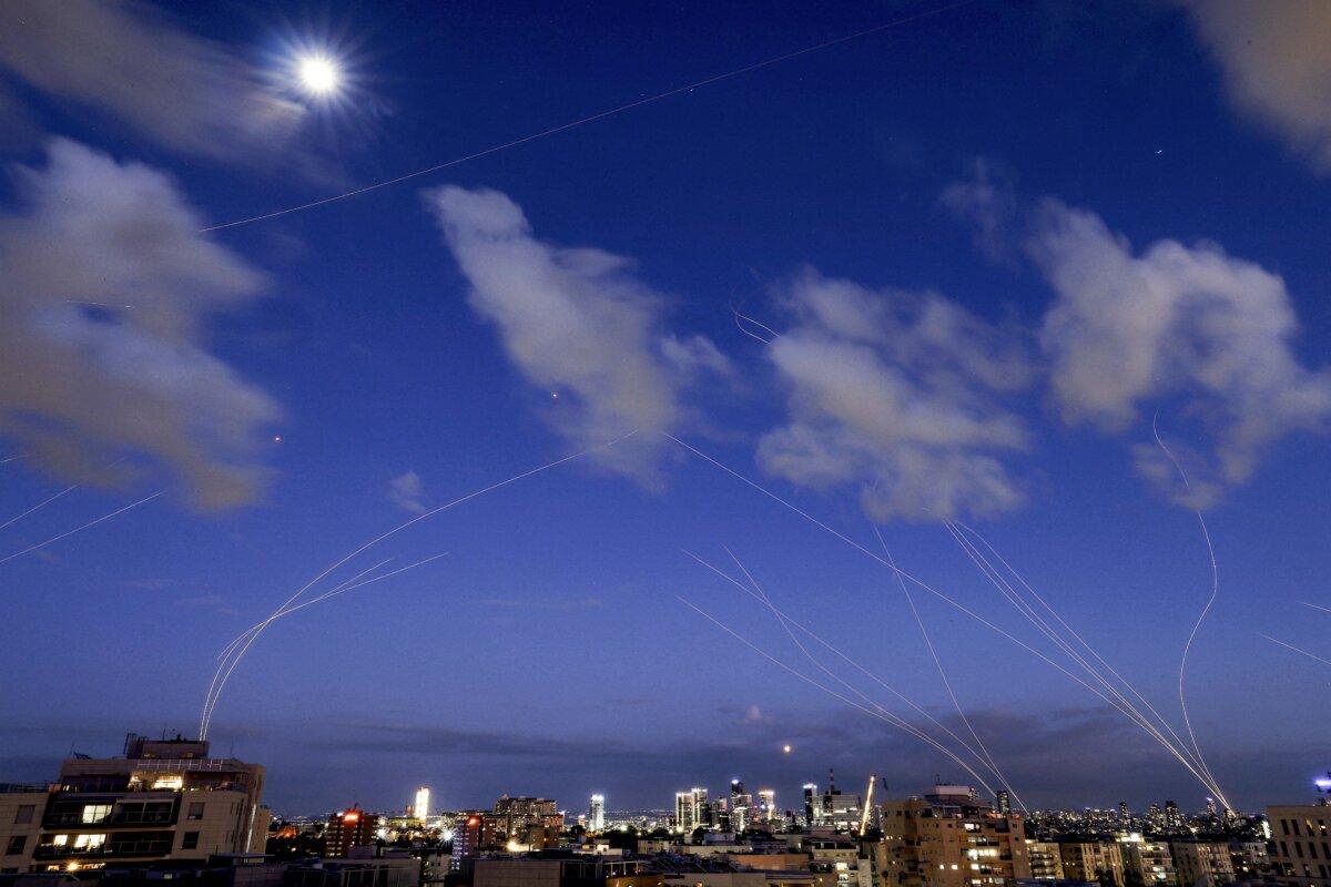 This long exposure shows trails and explosions from projectile interceptions by Israel's Iron Dome missile defence system over Tel Aviv, on Feb. 28, 2026. (Jack Guez / AFP via Getty Images)