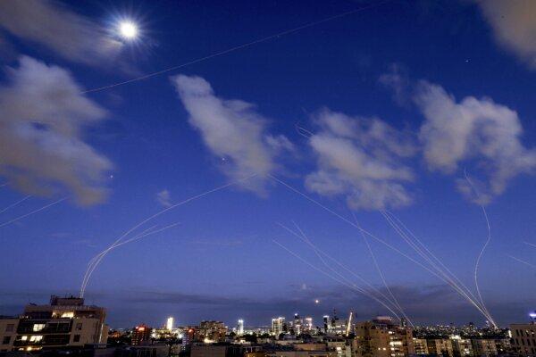 This long exposure shows trails and explosions from projectile interceptions by Israel's Iron Dome missile defense system over Tel Aviv, on Feb. 28, 2026. (Jack Guez/AFP via Getty Images)