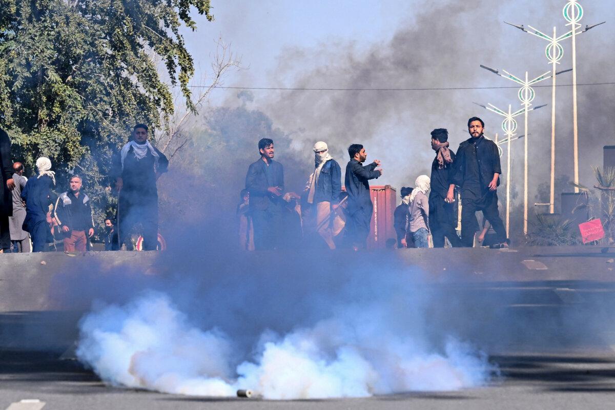 People disperse after riot police fired tear gas shells during their attempt to storm the U.S. Embassy in Islamabad on March 1, 2026. (Aamir Qureshi/AFP via Getty Images)