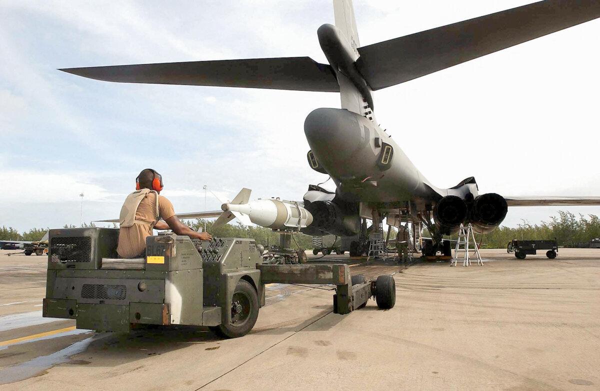 A U.S. Air Force weapons loader delivers a 2,000lb bomb for loading into a B1 bomber at the Diego Garcia base, Chagos Islands, on 22 Oct. 2001. (USAF/DOD/AFP via Getty Images)