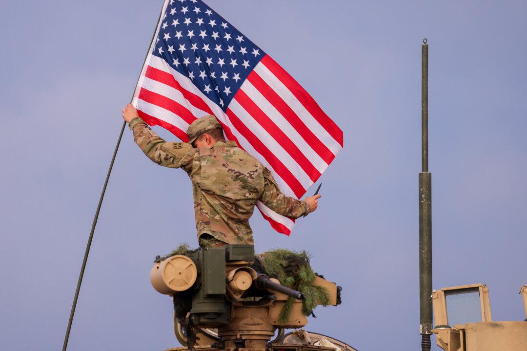 (Top) U.S. Army Col. Scott D. Wilkinson delivers a message to members of the 2nd Brigade Combat Team of the 101st Airborne Division prior to their departure for Europe in Fort Campbell, Ky., on July 6, 2022. (Bottom Left) Military vehicles are seen from Air Force One at Fort Bragg in Fort Bragg, N.C., on Feb. 13, 2026. (Bottom Right) A member of the U.S. Army 4th Infantry Division hoists an American flag onto his tank while participating in the NATO Iron Wolf military exercises in Pabrade, Lithuania, on Oct. 26, 2022. (Brett Carlsen/Getty Images, Nathan Howard/Getty Images, Sean Gallup/Getty Images)