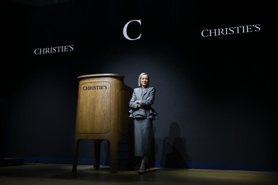 LONDON, ENGLAND - MARCH 05: Bonnie Brennan, CEO of Christie's poses next to The LoveFrom Christie's Rostrum at Christie's on March 05, 2026 in London, England. The LoveFrom Christie's Rostrum is a 2026 redesign of the auction house's historic mahogany stand that was originally commissioned by founder James Christie from Thomas Chippendale in the late 18th century. While the original was destroyed during the London Blitz in 1941, the design remained a symbol of the auction house's heritage. Jony Ive and the LoveFrom collective have reinterpreted the rostrum to mark Christie's 260th anniversary. (Photo by Jaimi Joy/Getty Images)