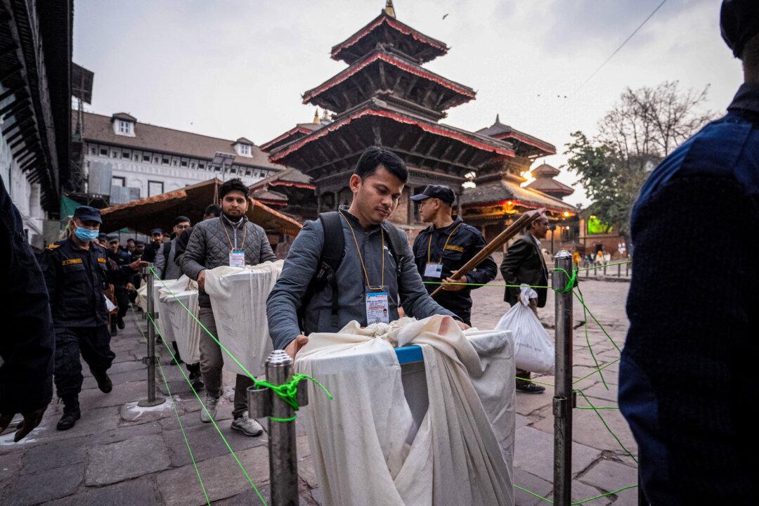 TOPSHOT - Security personnel escort as electoral officials carry ballot boxes to the counting centre after voting ends at a polling station during Nepal's general election in Kathmandu on March 5, 2026. Nepal voted on March 5 for a new parliament in a high-stakes showdown between an entrenched old guard and a powerful youth movement, six months after deadly anti-corruption protests toppled the government. (Photo by Prabin RANABHAT / AFP via Getty Images)