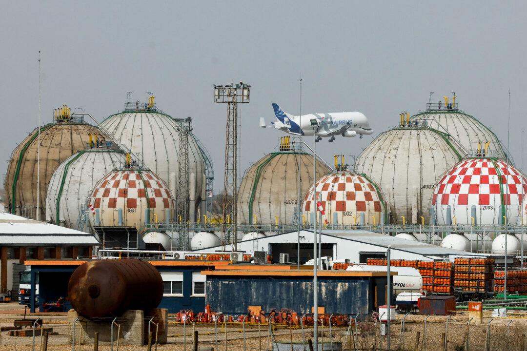 An Airbus Beluga transport airliner flies over storage tanks at a Liquefied Petroleum Gas (LPG) factory in Pinto, near Madrid, on March 5, 2026. Markets have been roiled much of the week as the conflict between the United States and Iran effectively closed shipping through the Strait of Hormuz, where a fifth of the world's crude oil travels as well as considerable liquefied natural gas (LNG) supplies travel through. (Photo by Oscar DEL POZO / AFP via Getty Images)