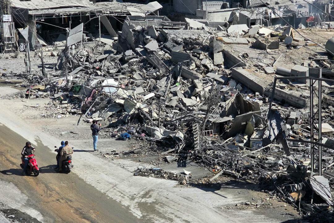 Motorists ride past the rubble of destroyed buildings at the site of an Israeli airstrike in the southern Lebanese city of Nabatieh on March 5, 2026. Israel launched on March 5 a fresh wave of strikes on Iran, which stepped up its attacks on Gulf nations Qatar and Bahrain, as the Middle East war spread throughout the region and beyond. (Photo by Mouhammad al-ZANATY / AFP via Getty Images)