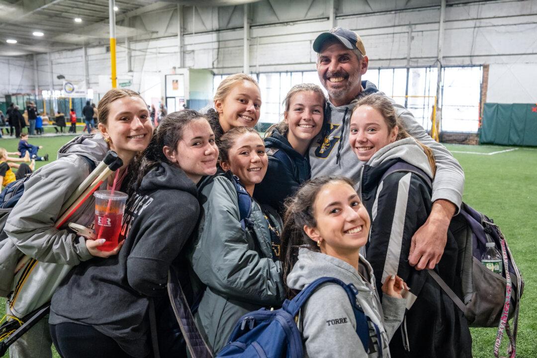 (Top) Coaches speak with the 2027 YJ Gaghan-Torre and 2028 YJ Bertolone girls lacrosse teams at KK Athletics Indoor Sports in Farmingville, N.Y., on March 1, 2026. (Bottom) Lacrosse coach Nick Torre hugs players from the 2027 YJ Gaghan-Torre team at KK Athletics Indoor Sports in Farmingville, N.Y., on March 1, 2026. (Samira Bouaou/The Epoch Times)