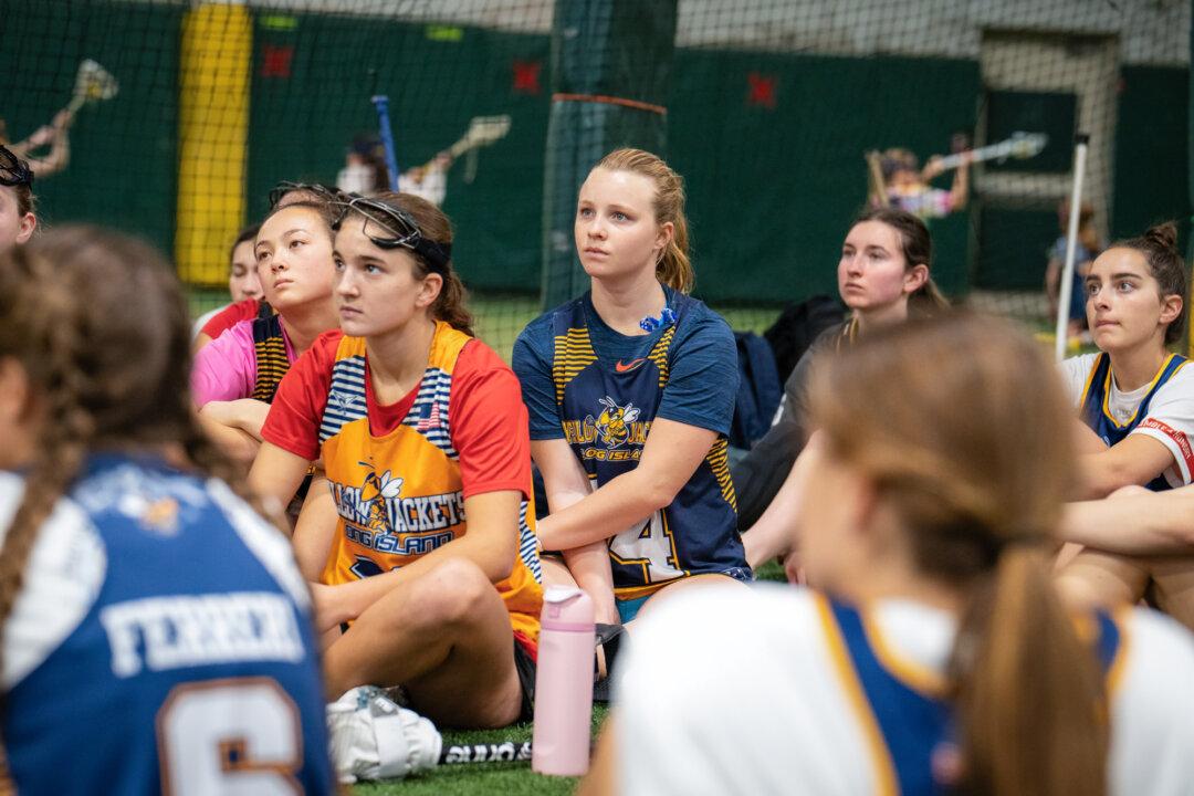 (Top L–R, Bottom Left–Right) Coaches Nick Torre, Al Bertolone, and Jen Maget talk to lacrosse girls teams 2027 YJ Gaghan-Torre and 2028 YJ Bertolone at KK Athletics Indoor Sports in Farmingville, N.Y., on March 1, 2026. Torre said that parents should really look at the goal as finding a college that’s a good fit, where their children can play a sport, rather than sending them to college in order to play a sport. (Samira Bouaou/The Epoch Times)