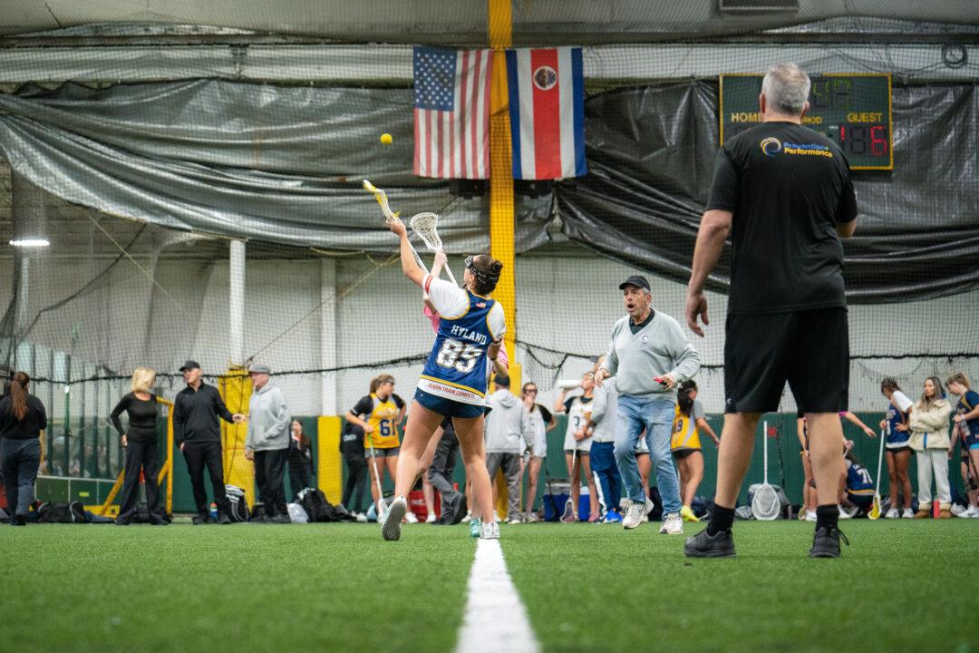 (Top L–R, Bottom Left–Right) Coaches Nick Torre, Al Bertolone, and Jen Maget talk to lacrosse girls teams 2027 YJ Gaghan-Torre and 2028 YJ Bertolone at KK Athletics Indoor Sports in Farmingville, N.Y., on March 1, 2026. Torre said that parents should really look at the goal as finding a college that’s a good fit, where their children can play a sport, rather than sending them to college in order to play a sport. (Samira Bouaou/The Epoch Times)