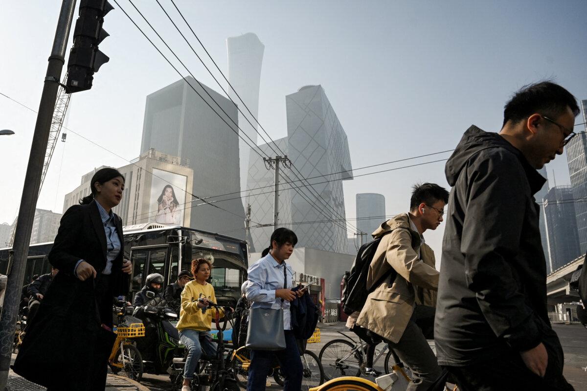 People cross a road in Beijing’s business district on April 10, 2025. (Greg Baker/AFP via Getty Images)
